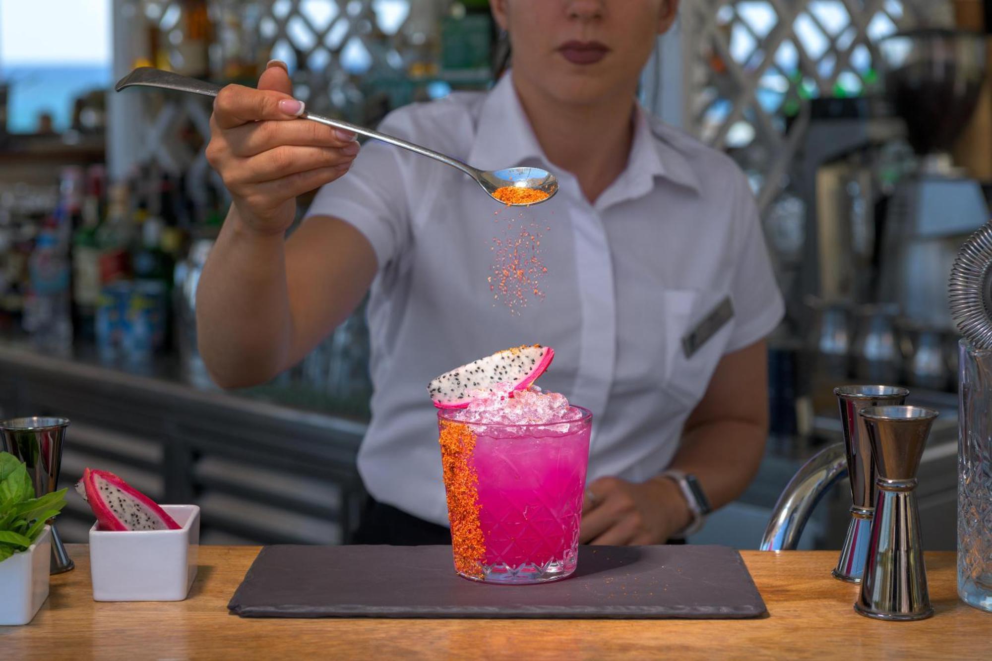 Rodos Palladium Leisure&Wellness Kallithéa Esterno foto A bartender adding a garnish to a cocktail